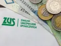 Logo ZUS i polskie banknoty oraz monety.