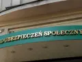 Złoty napis "ZAKŁAD UBEZPIECZEŃ SPOŁECZNYCH" na zielonym tle.