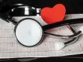Stetoskop i czerwone serce na tle EKG.