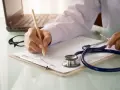 Lekarz pisze receptę, która może pomóc w uzyskaniu orzeczenia o niepełnosprawności na różne choroby.
