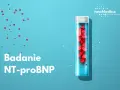 Probówka z czerwonymi próbkami i tekst "Badanie NT-proBNP" na niebieskim tle.