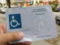 Karta parkingowa dla niepełnosprawnych, z symbolem wózka inwalidzkiego i oznaczeniem PL. Ułatwia parkowanie w mieście.
