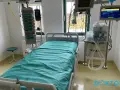 Łóżko szpitalne na oddziale intensywnej terapii z aparaturą medyczną.