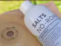 Butelka płynu "Salts No-Roma" i element stomijny z zaznaczonymi wymiarami.
