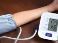 Ramię z mankietem ciśnieniomierza i wyświetlaczem pokazującym 117/68 mmHg, tętno 85.