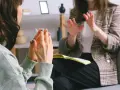 Dwie kobiety rozmawiają w gabinecie, jedna gestykuluje.