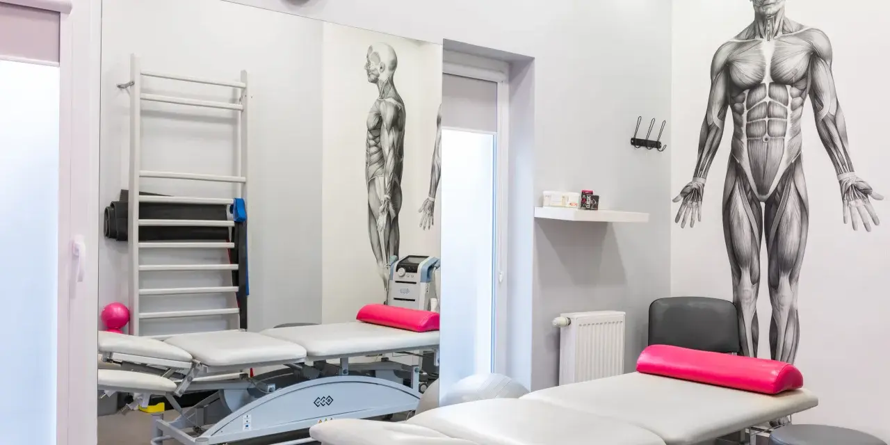 Gabinet rehabilitacyjny z łóżkami, drabinką i aparaturą do magnetoterapii. Dowiedz się, co to magnetoterapia i jak może pomóc w leczeniu.