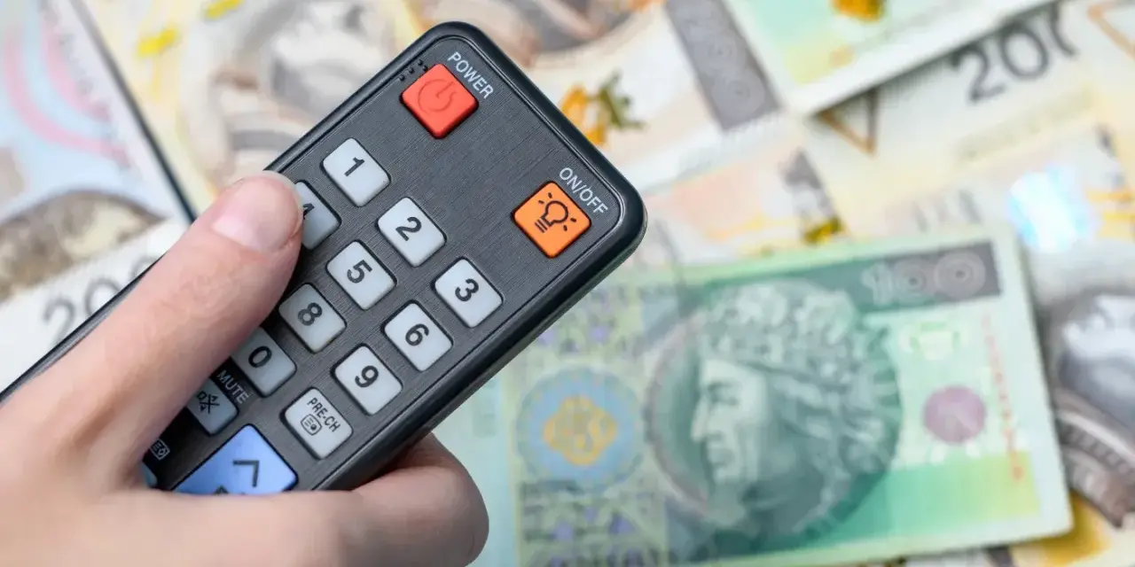 Pilot w dłoni, na tle polskich banknotów. Czy to symbol zwolnienia z abonamentu RTV i oszczędności?