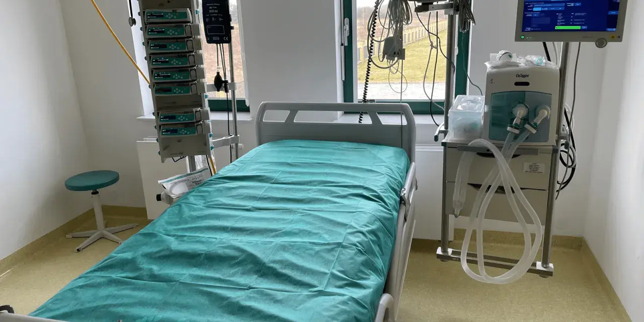 Łóżko szpitalne na oddziale intensywnej terapii z aparaturą medyczną.