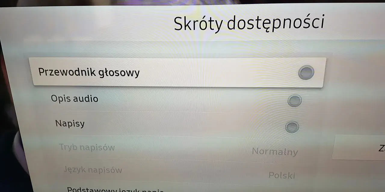Menu telewizora z opcjami "Przewodnik głosowy", "Opis audio", "Napisy", "Tryb napisów", "Język napisów".