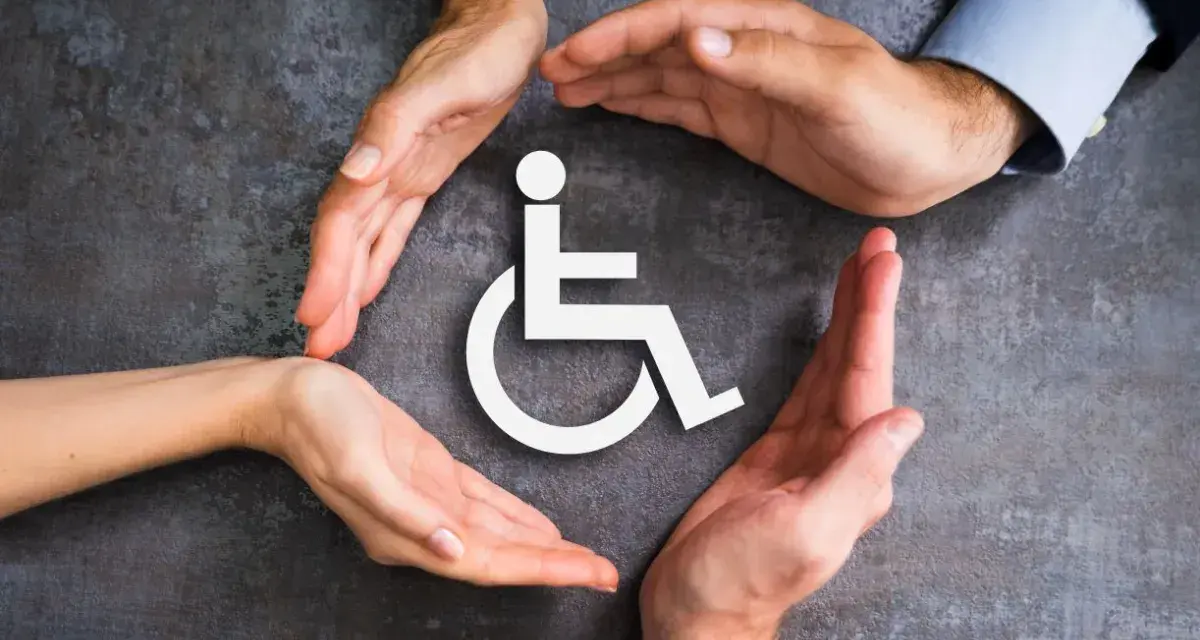 Symbol wózka inwalidzkiego otoczony dłońmi symbolizującymi wsparcie i opiekę.
