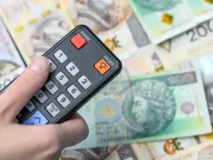 Pilot w dłoni, na tle polskich banknotów. Czy to symbol zwolnienia z abonamentu RTV i oszczędności?