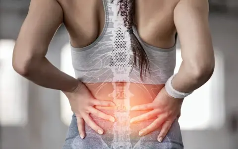 Kobieta z bólem w odcinku lędźwiowym kręgosłupa, wskazującym na dyskopatię lędźwiową i jej objawy neurologiczne.