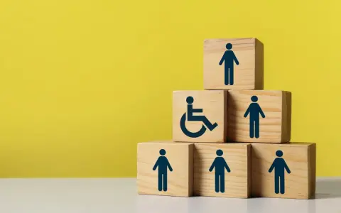 Drewniane klocki symbolizują wsparcie dla osób z niepełnosprawnościami, jak 500 plus dla niepełnosprawnych.