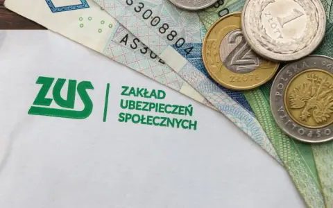 Logo ZUS i polskie banknoty oraz monety.