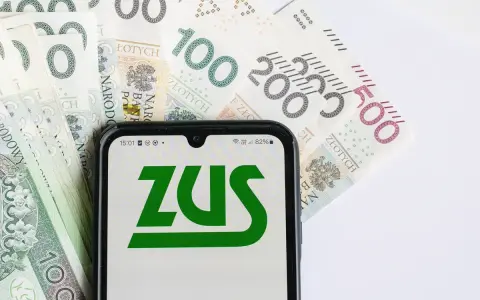 ZUS świadczenie wspierające na ekranie telefonu, otoczone polskimi banknotami.