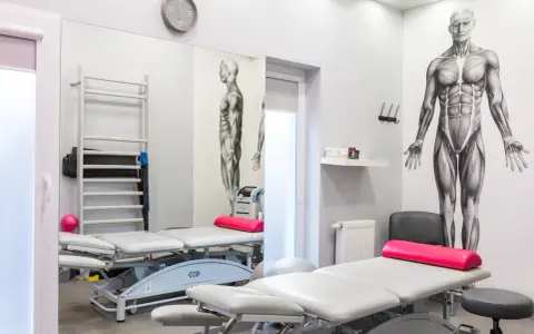 Gabinet rehabilitacyjny z łóżkami, drabinką i aparaturą do magnetoterapii. Dowiedz się, co to magnetoterapia i jak może pomóc w leczeniu.