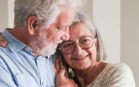 Uśmiechnięta para seniorów, która cieszy się życiem i przywilejami po 75 roku życia. Ich miłość kwitnie.