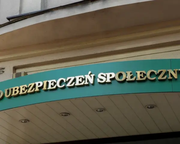 Złoty napis "ZAKŁAD UBEZPIECZEŃ SPOŁECZNYCH" na zielonym tle.