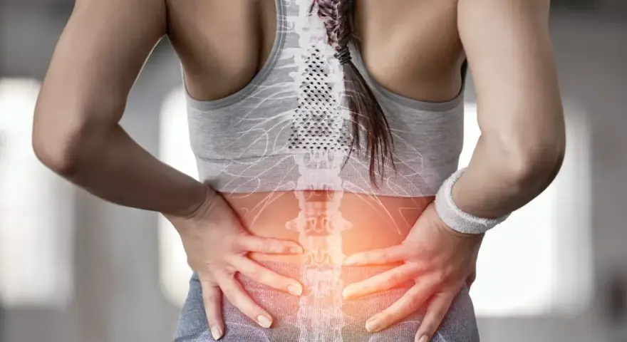 Kobieta z bólem w odcinku lędźwiowym kręgosłupa, wskazującym na dyskopatię lędźwiową i jej objawy neurologiczne.