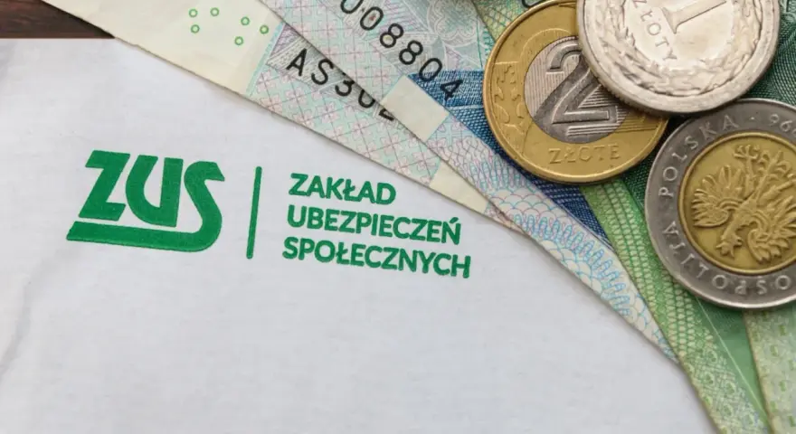 Logo ZUS i polskie banknoty oraz monety.