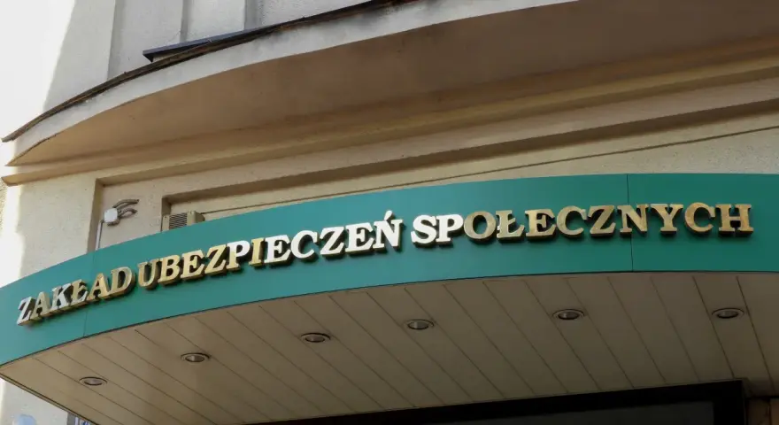 Złoty napis "ZAKŁAD UBEZPIECZEŃ SPOŁECZNYCH" na zielonym tle.
