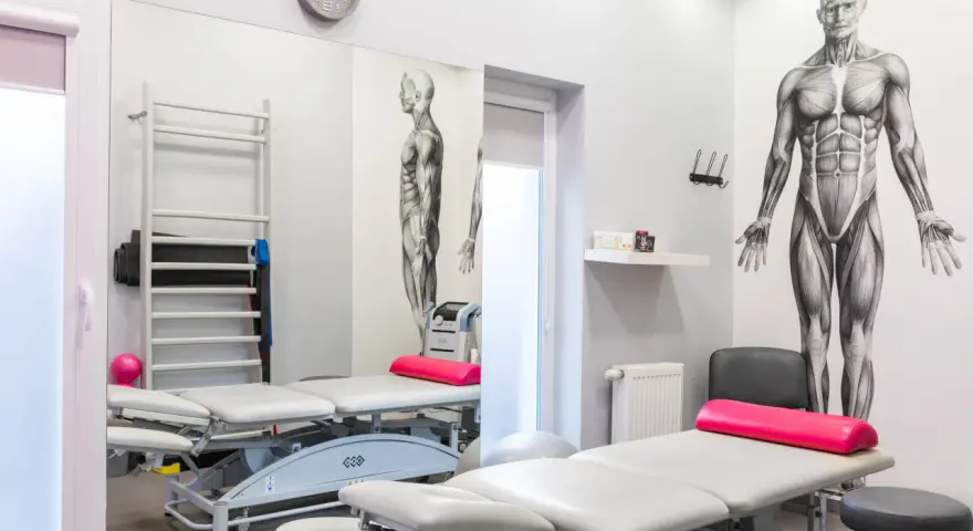 Gabinet rehabilitacyjny z łóżkami, drabinką i aparaturą do magnetoterapii. Dowiedz się, co to magnetoterapia i jak może pomóc w leczeniu.