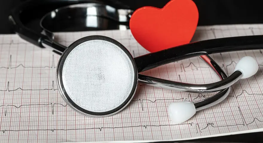 Stetoskop i czerwone serce na tle EKG.