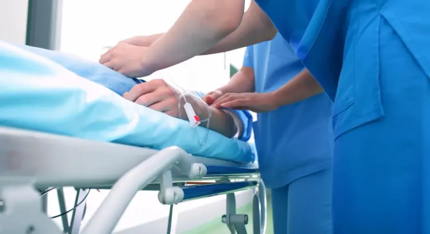 Pacjent na łóżku szpitalnym, pielęgniarki przy kroplówce. Czy to początek drogi do pokonania choroby a?