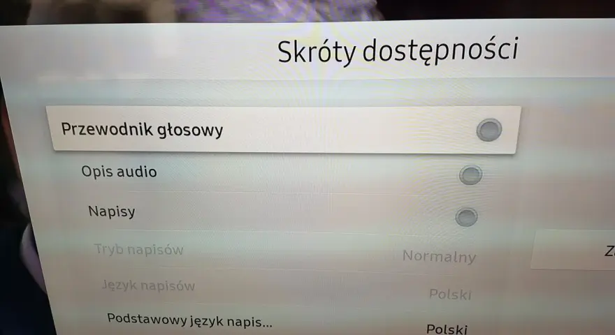 Menu telewizora z opcjami "Przewodnik głosowy", "Opis audio", "Napisy", "Tryb napisów", "Język napisów".
