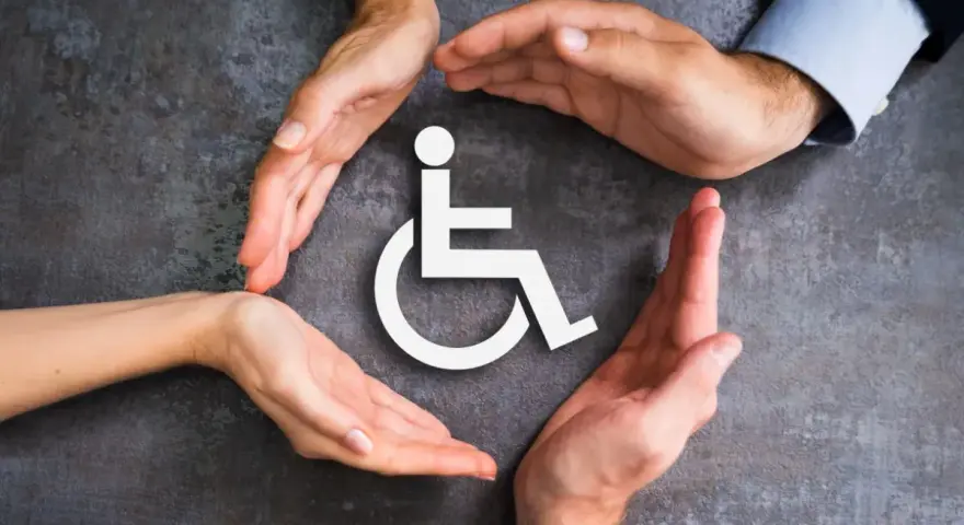 Symbol wózka inwalidzkiego otoczony dłońmi symbolizującymi wsparcie i opiekę.