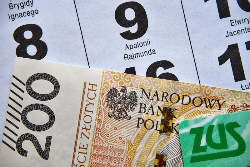 200 zł i zielona karta ZUS na tle kalendarza z datami. Może to być numer świadczenia ZUS.